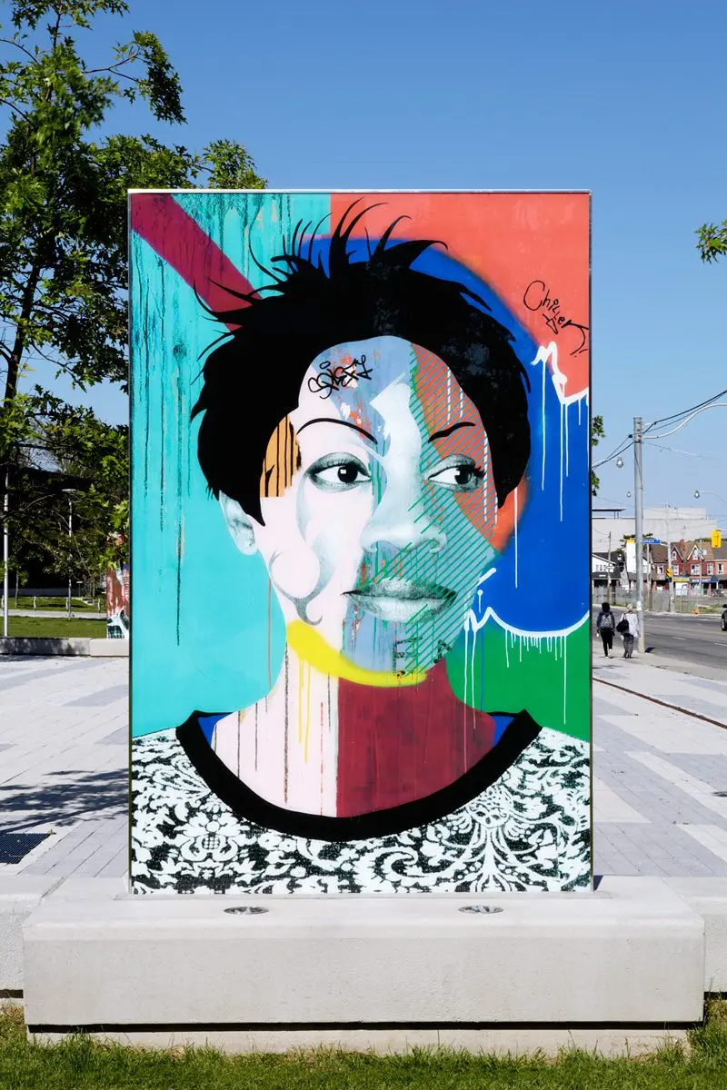 Painted portrait by Toronto artist Benny Bing, displayed outdoors in Regent Park